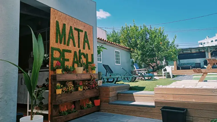 Letras MATA BEACH em musgo no jardim, junto ao deck de madeira
