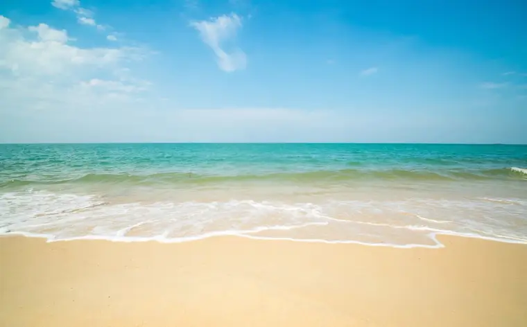 Areal dourado e mar azul num dia de sol